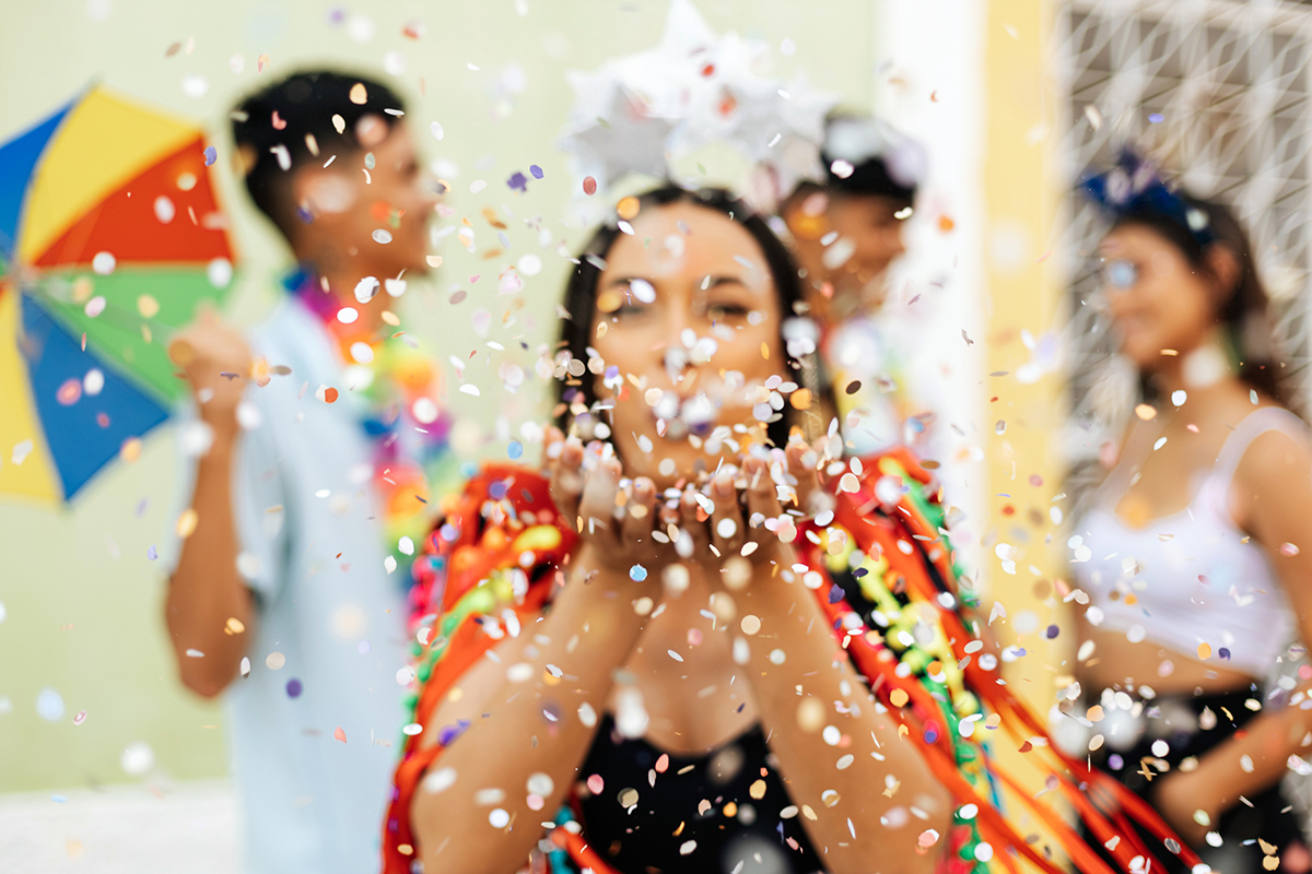 A person celebrating with colorful confetti, symbolizing the excitement and opportunity of low mortgage rates in Arizona, with others joining the festive mood.